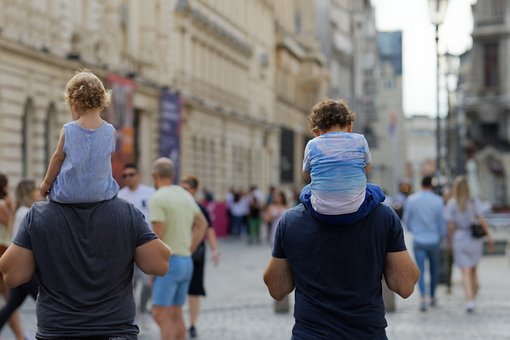 31 July 2022 - Men with small children on shoulders walking